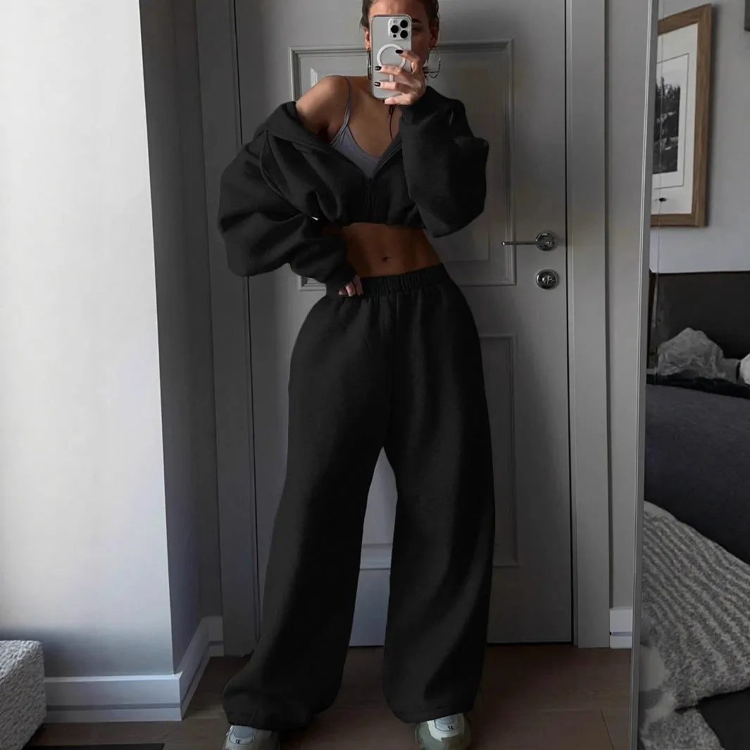 Man wearing a long sleeve sweater and matching trousers from a grey two-piece sports leisure suit set.