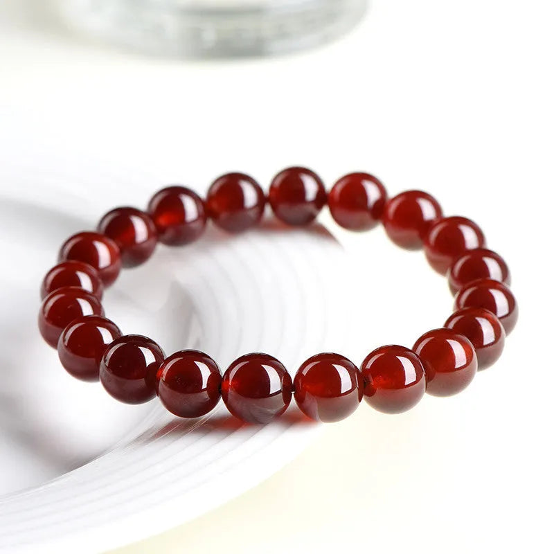 Natural orange red garnet crystal ball bracelet with retro Ruyi design on wrist