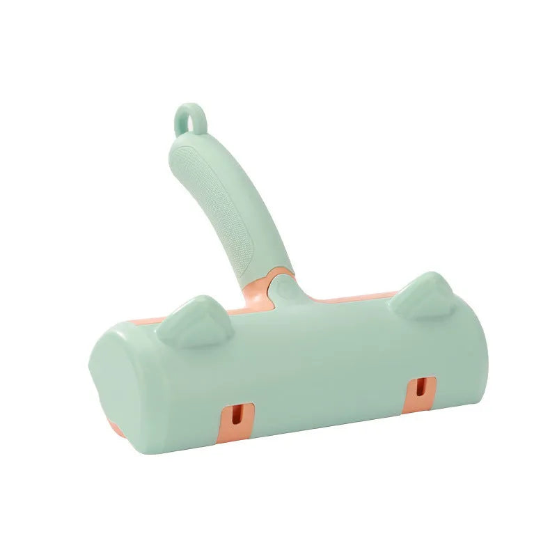 Mint green manual cat hair removal brush with detachable fur collection bin on a grey sofa