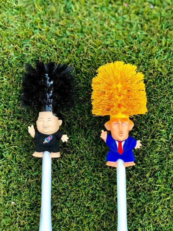Yellow plastic Trump novelty toilet brush with a hanging slot on the handle.