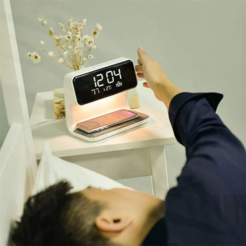 White bedside lamp with integrated wireless charging pad, LCD alarm clock screen, and touch-sensitive dimming controls.