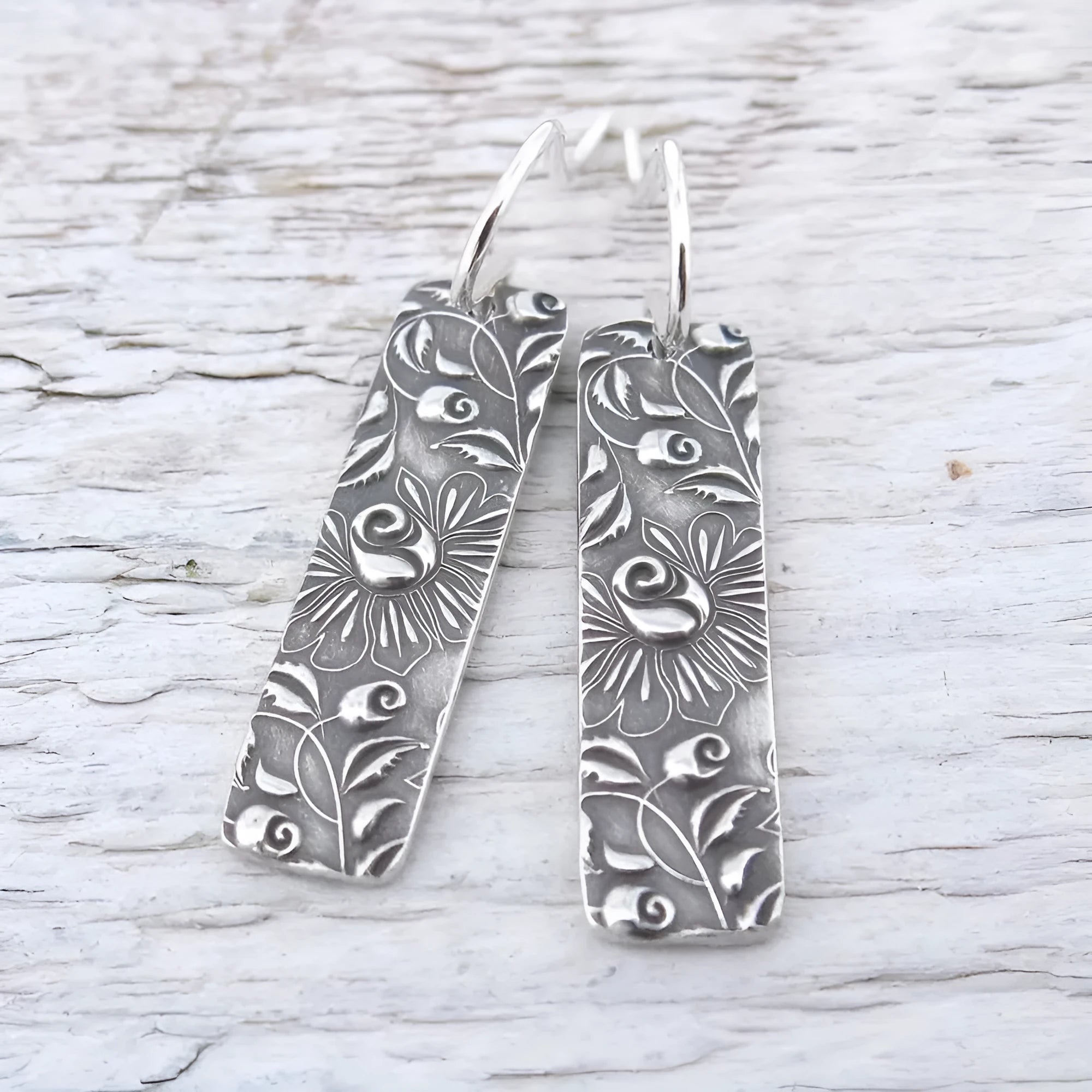 Silver geometric long earrings with carved vine detailing measuring 20 cm
