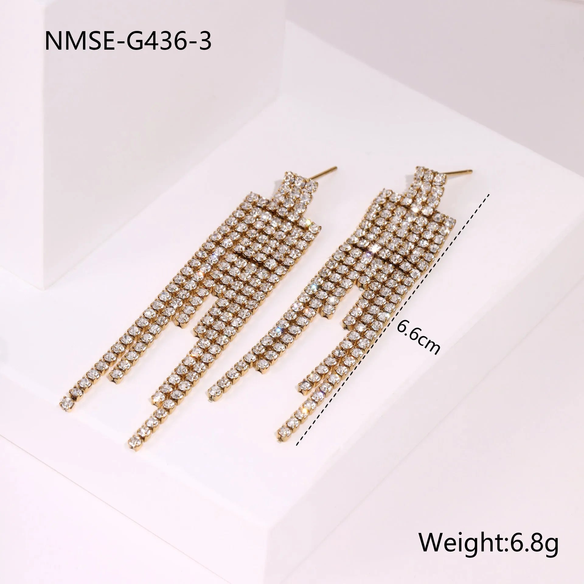 Gold-colour stainless steel earrings with heart and star tassel designs on a white background.