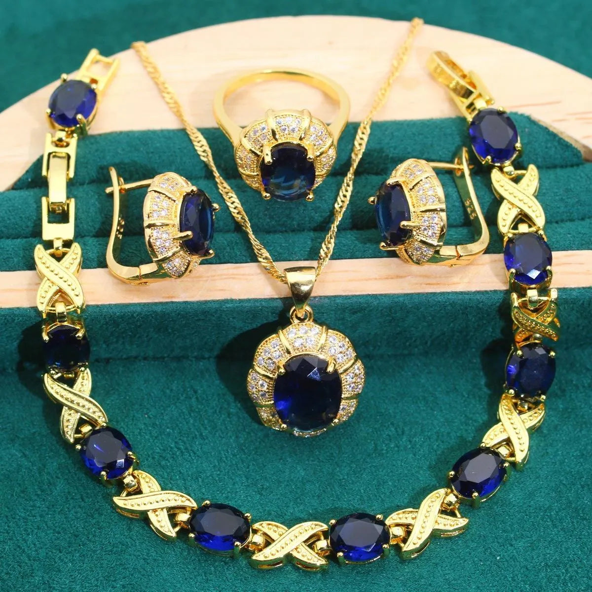 18k gold plated four-piece jewellery set with synthetic cubic zirconia stones in Raytheon cut, showing necklace, earrings, ring, and bracelet