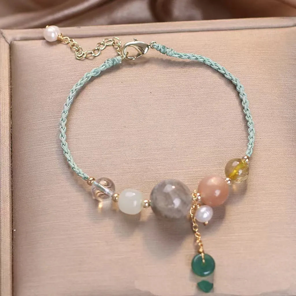 Women's hand-woven crystal and sequin bracelet with a silver peace buckle fastening on a wrist.