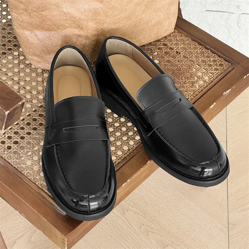 Black men's leather slip-on derby shoes on a white background