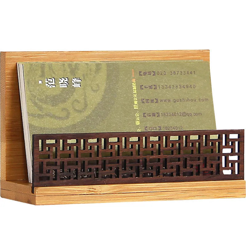 Geometric bamboo business card holder on a desk, showing natural wood grain and card slots.