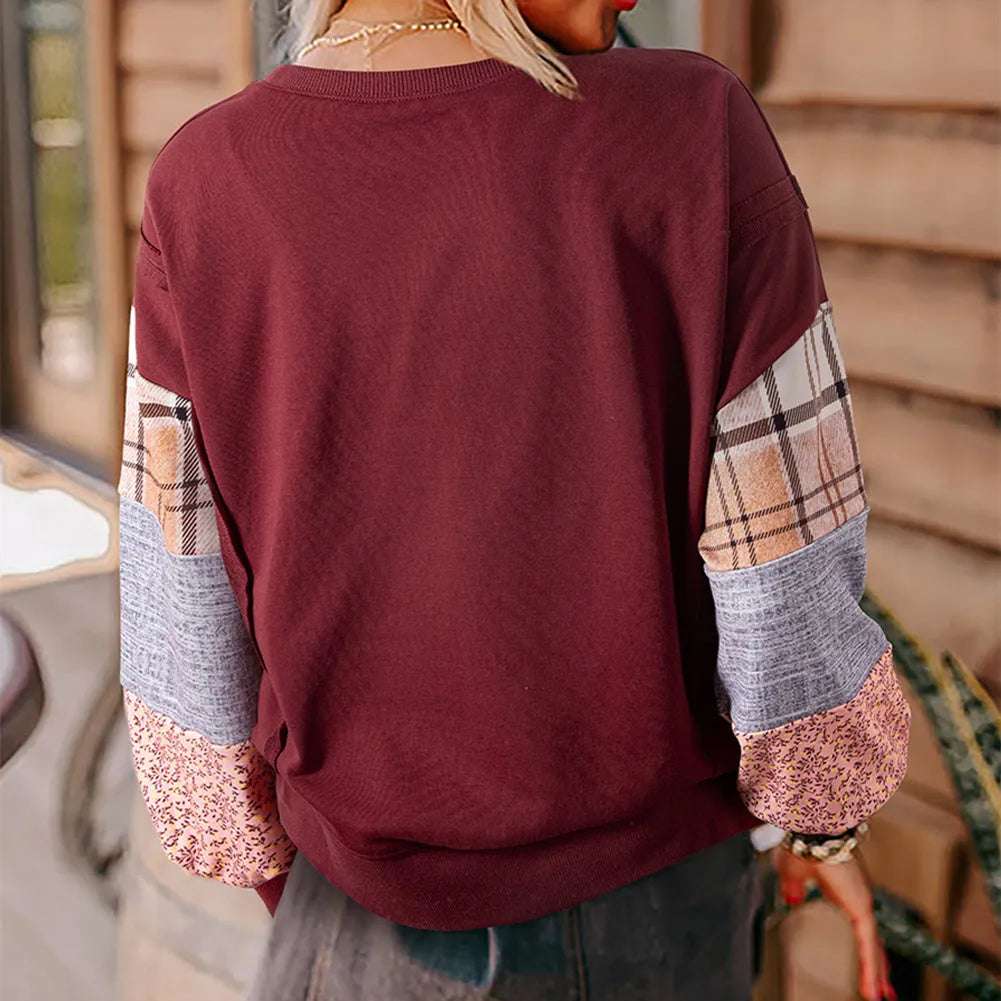 Women's beige and red plaid stitch long-sleeved loose pullover top on a hanger.