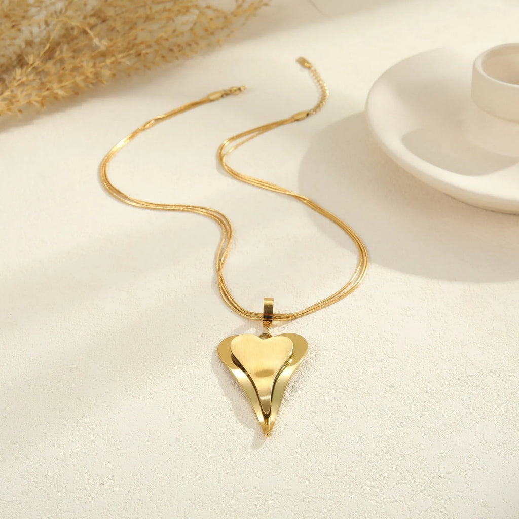 Geometric double heart pendant on a stainless steel snake bones chain necklace in gold or steel finish.