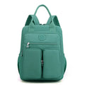 Large purple waterproof travel backpack showing front organiser pocket and internal laptop and camera compartments.