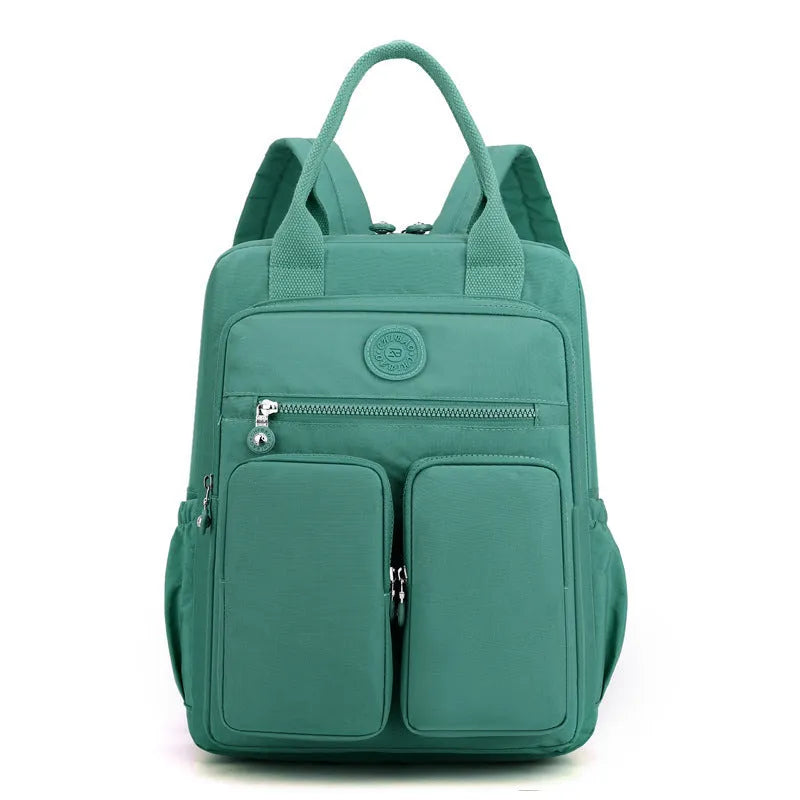 Large purple waterproof travel backpack showing front organiser pocket and internal laptop and camera compartments.