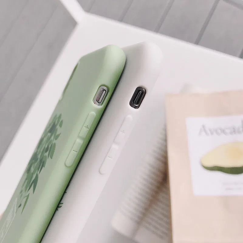 White silicone iPhone case with a detailed painted leaf and plant pattern on the back.
