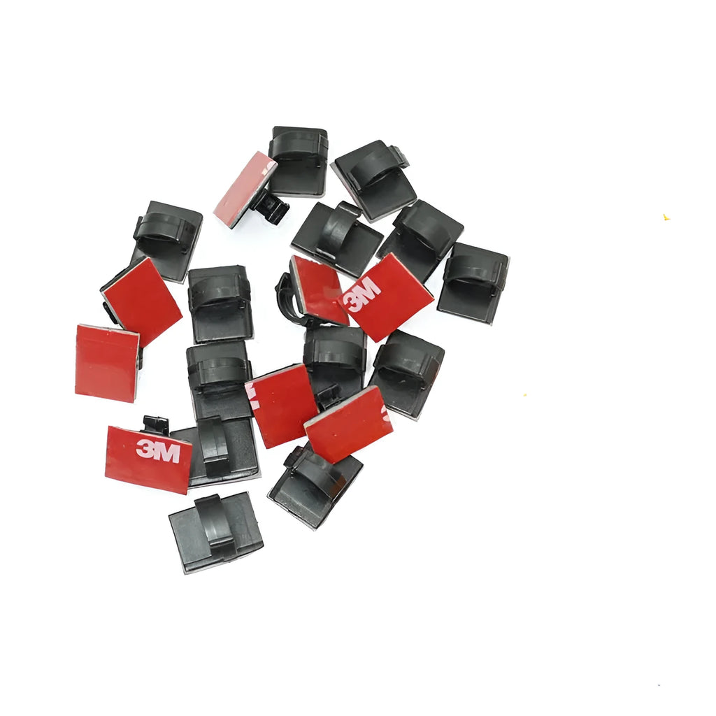 Black and white plastic self-adhesive cable clamps for wire management on a table.