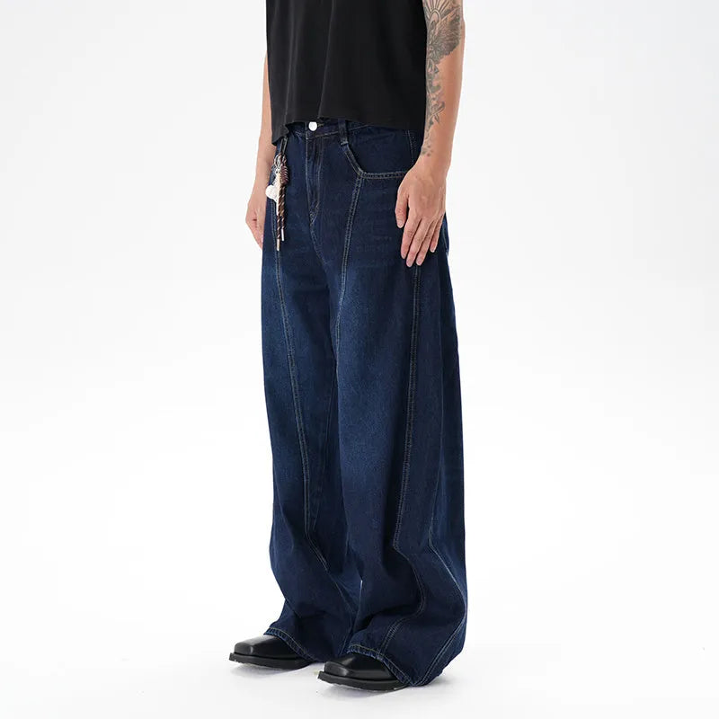 Dark blue wide leg jeans with a distressed wash and machete cut, laid flat.