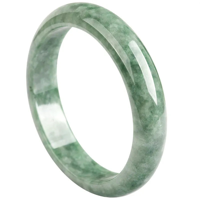 Women's simple bracelet with a natural green emerald bean gemstone on a wrist.