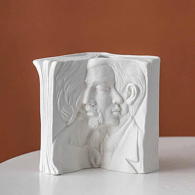 Ceramic book stand in lover design with glazed surface, approximately 15cm tall, on a wooden desk