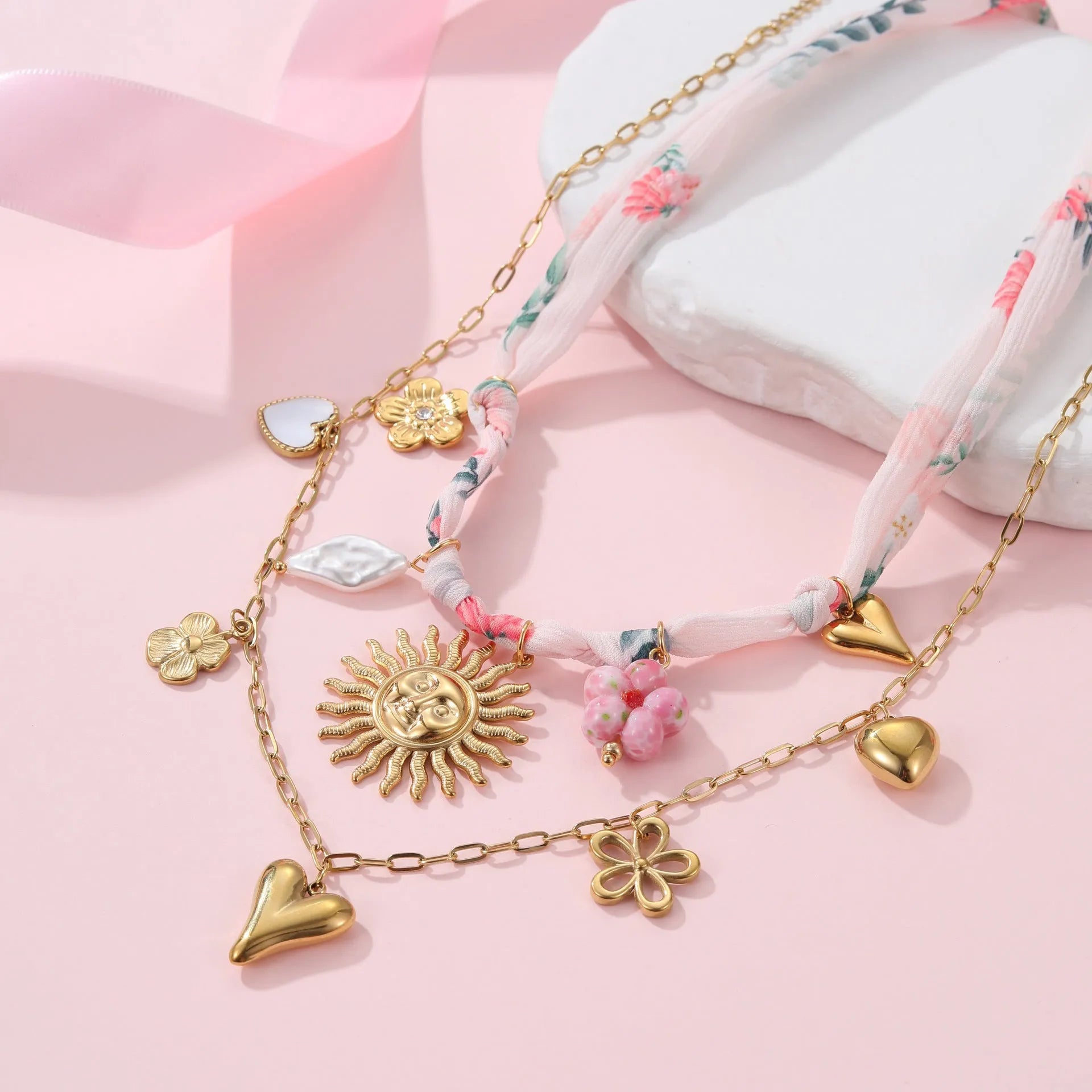 Stainless steel necklace with a geometric sun pendant on a regular chain, showing heart and ribbon sun style options.