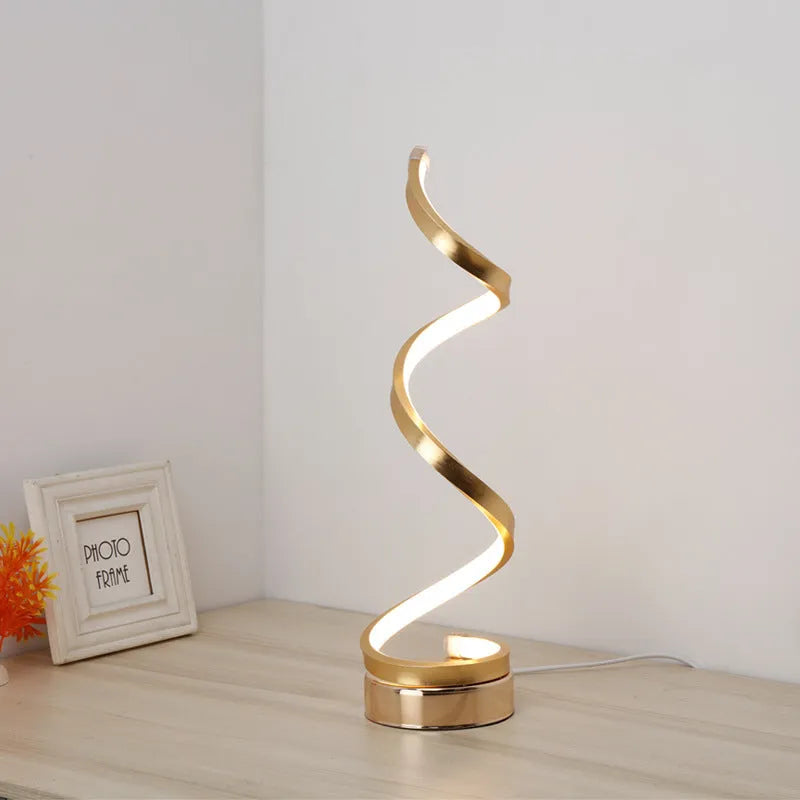 Minimalist black and white LED bedside lamp with aluminium shade and tri-colour dimming on a wooden table.