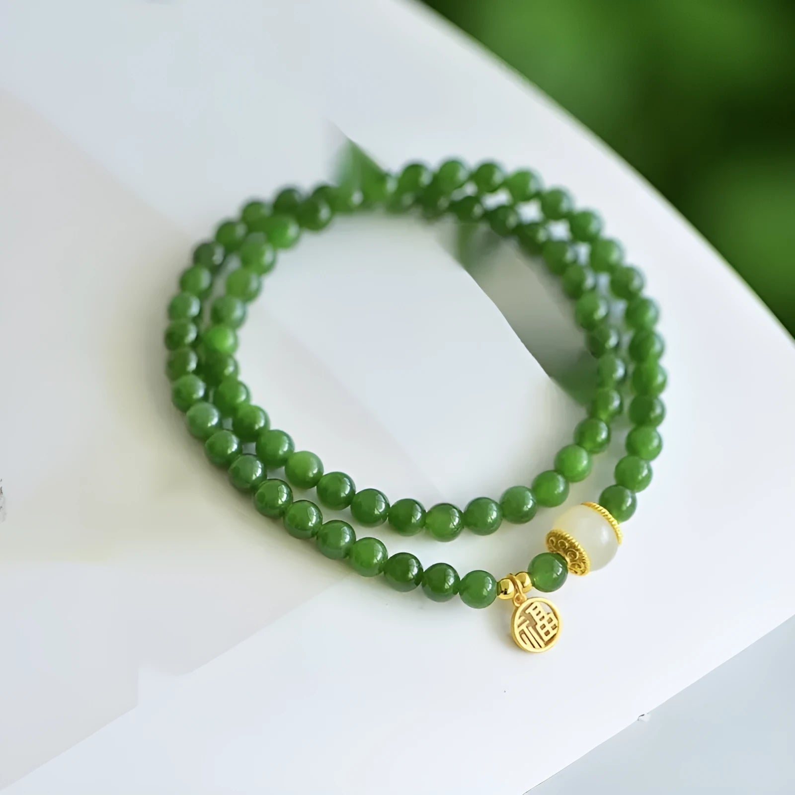 Women's double circle bracelet with natural Hetian jade beads and a central fu character charm.