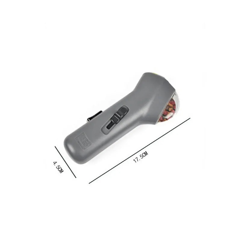 Grey pet snack catapult launcher measuring 18 cm long with spring trigger for 3-metre treat ejection