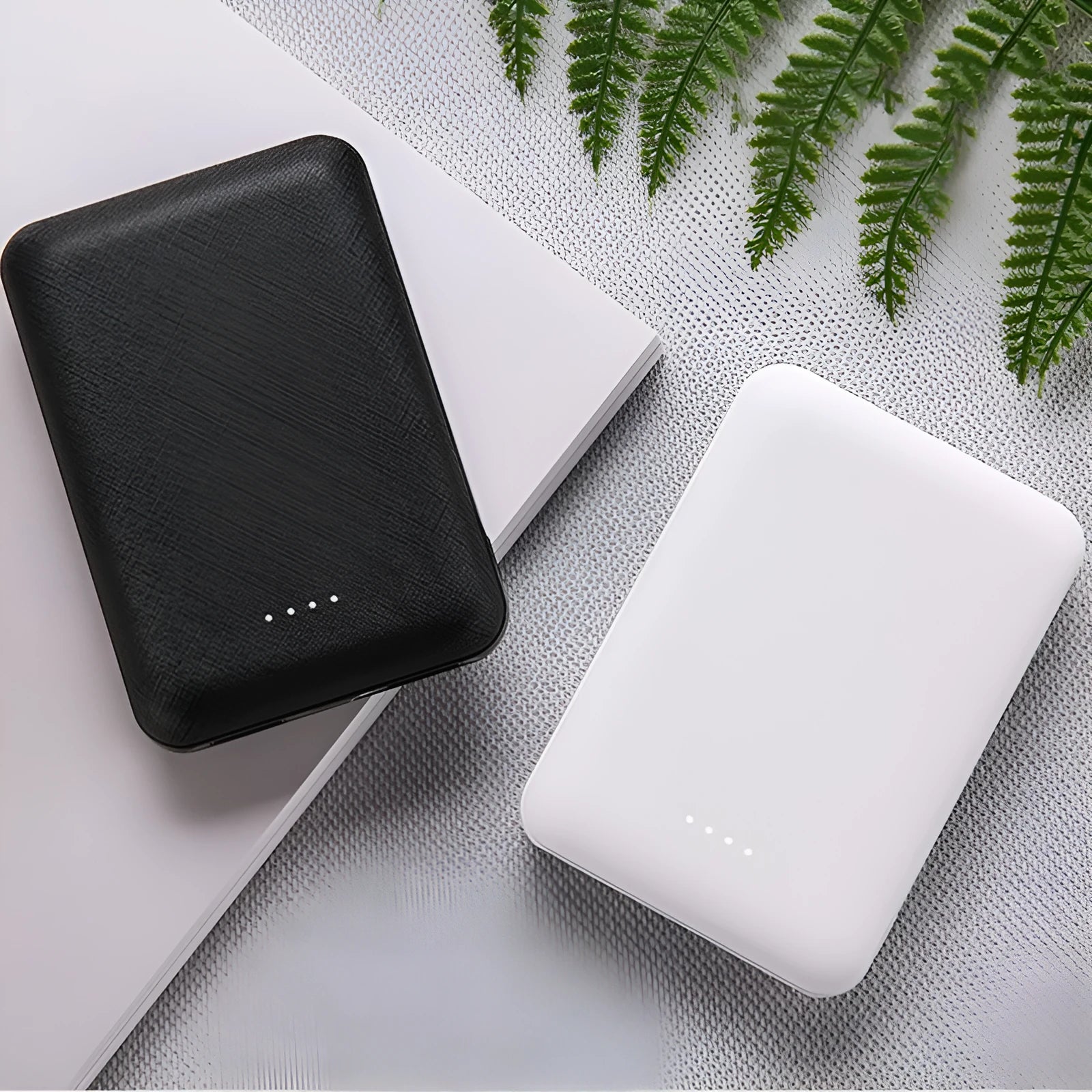 Slim 10,000mAh power bank in black or white with multiple USB ports showing 90x63x22mm dimensions
