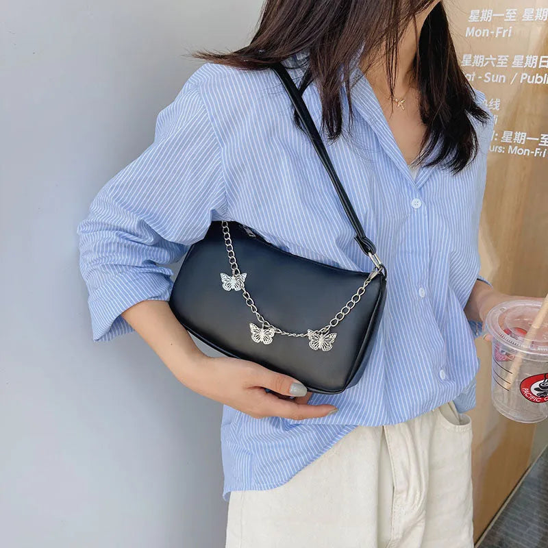 Black butterfly chain underarm bag showing three-dimensional pocket and adjustable metal chain strap