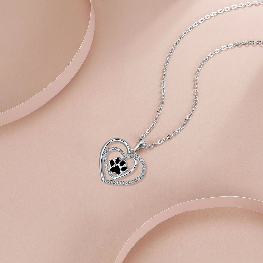 Women's copper necklace with dog paw and heart pendant on a cross chain.