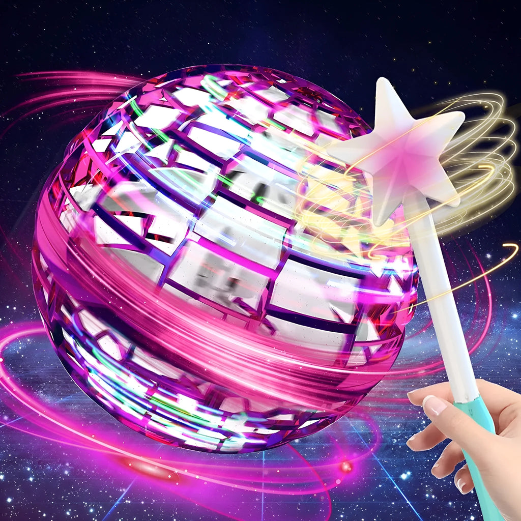 A child's hand holding a blue spinning flying ball toy with LED lights, with a magic wand nearby.