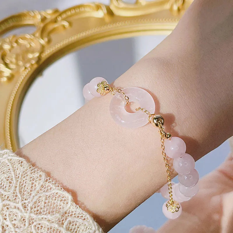 Women's pink crystal bracelet with peace buckle safety closure on wrist