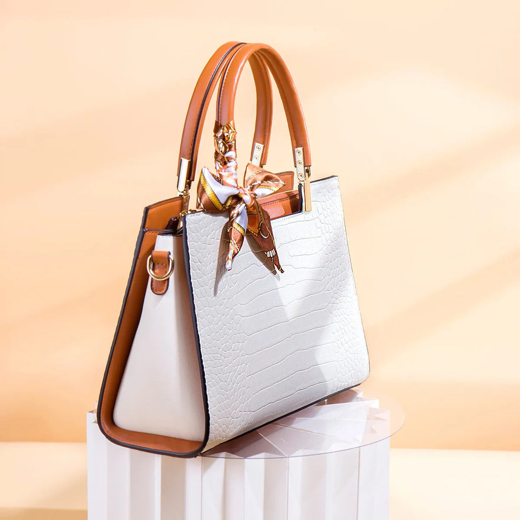 Women's milky white shoulder handbag with three interior compartments showing zipper changing bag, mobile phone pocket, and document storage
