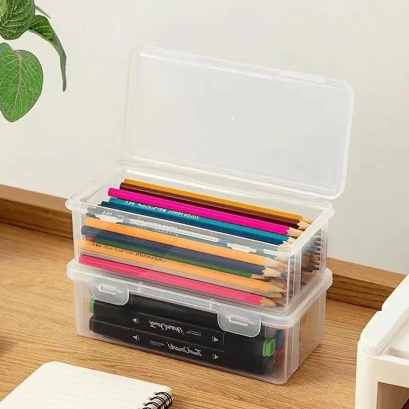 Transparent plastic stationery storage box with snap-lock lid containing coloured pencils and pens