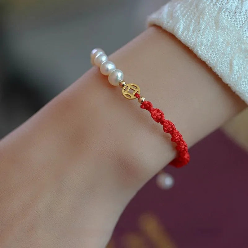 Women's pearl bracelet with braided red rope and gold plated fu character charm