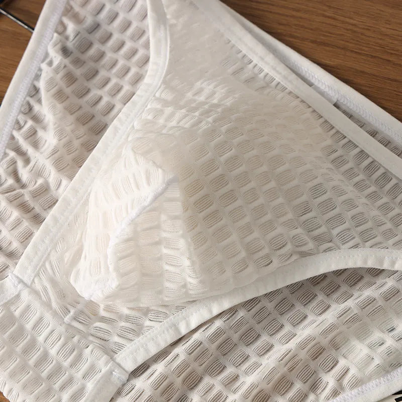 Men's low waist transparent lace underwear in white on a mannequin, showing the breathable fabric texture.