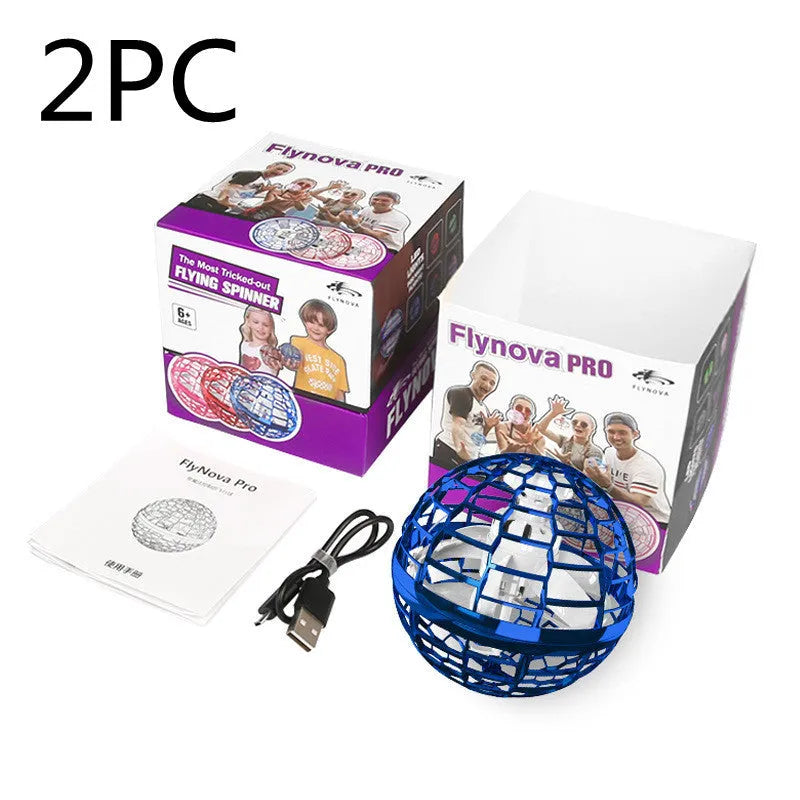 A child's hand holding a blue spinning flying ball toy with LED lights, with a magic wand nearby.