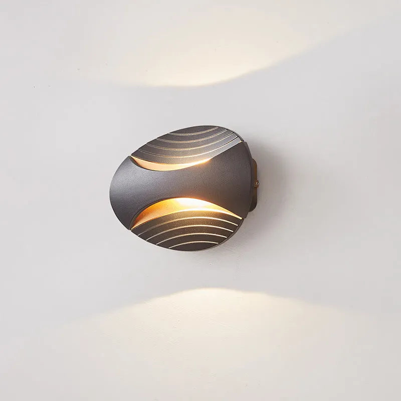 Modern minimalist aluminium wall lamp in black finish with LED light, mounted on a white wall.