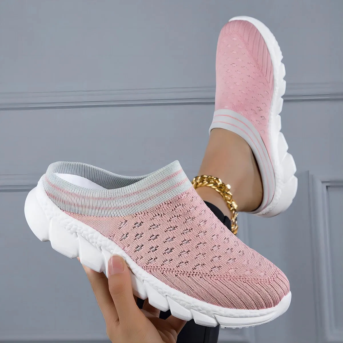 Women's black Flyknit slipper shoes with striped pattern and hollowed-out design on a white background.