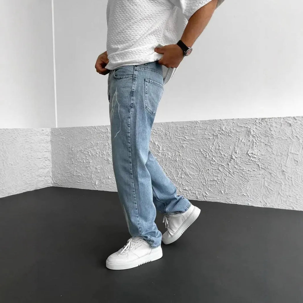 Men's blue straight-leg jeans with a loose wide-leg cut and printed design.