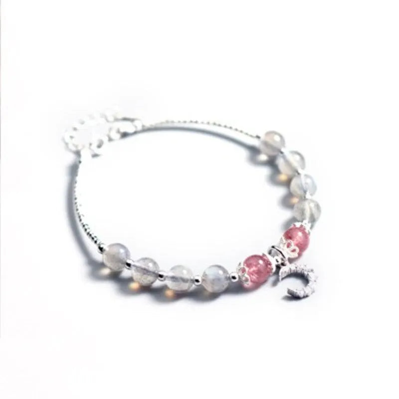 Handmade silver-tone adjustable bracelet with a moonstone bead and small crescent moon charm on a white background.