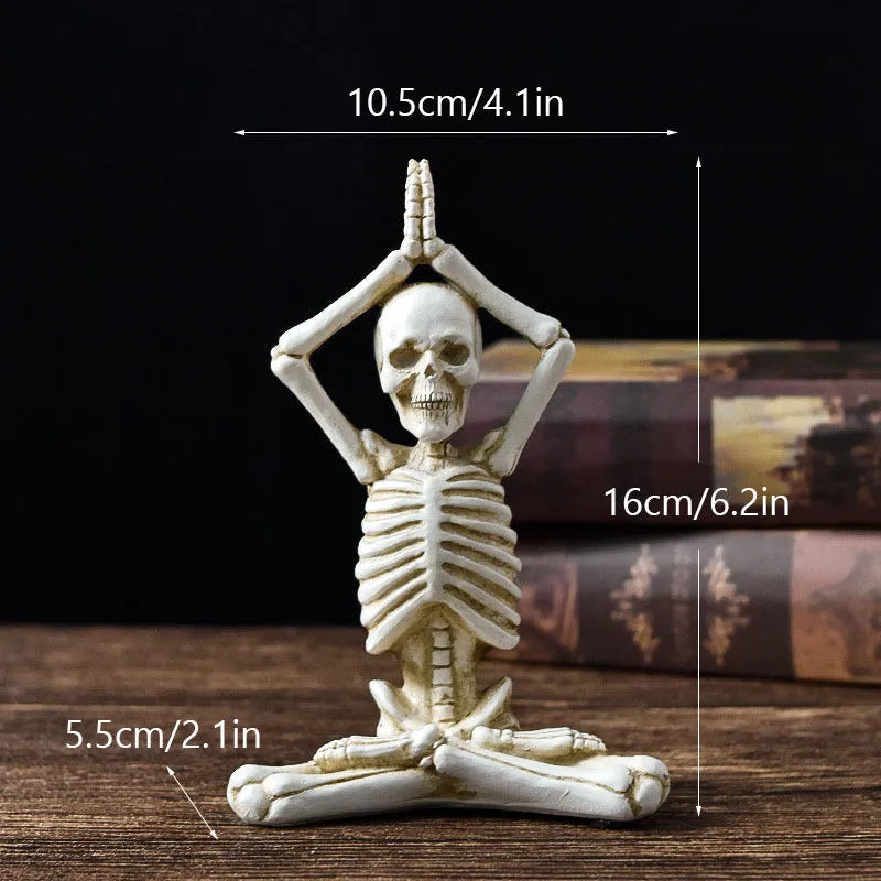 Hand-painted resin yoga pose skull skeleton ornament measuring 10.5-11cm wide on wooden desktop