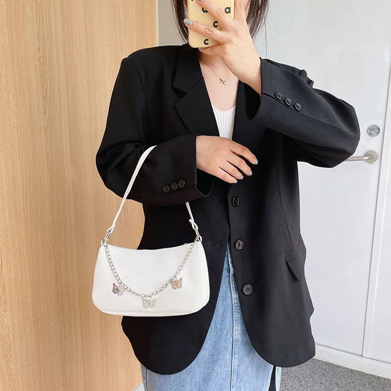 Black butterfly chain underarm bag showing three-dimensional pocket and adjustable metal chain strap