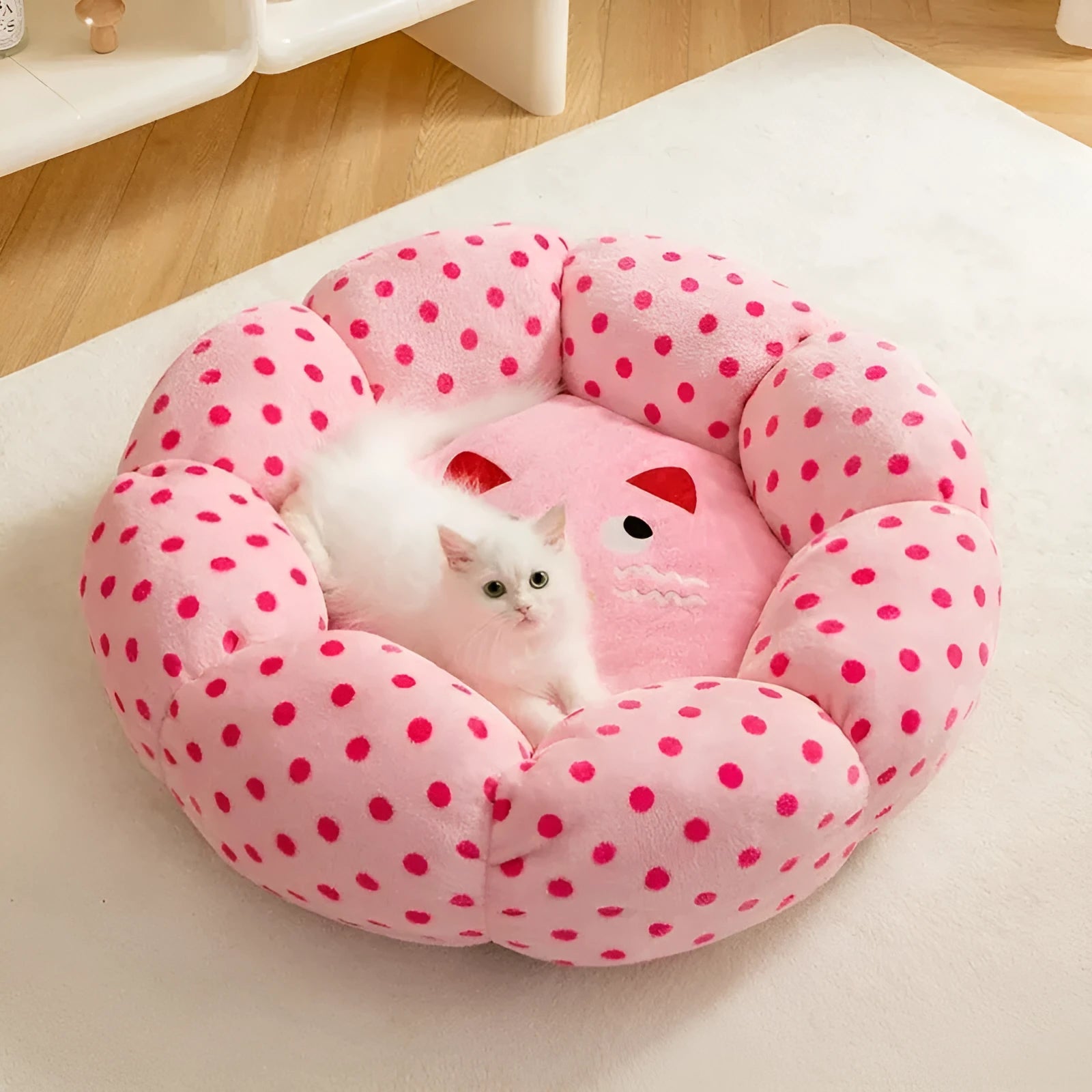 Pink dot pattern fabric cat bed shown in two circular sizes, 45cm and 65cm diameter.
