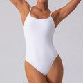 A woman wearing a slim, sleeveless dark brown yoga jumpsuit in a yoga pose.