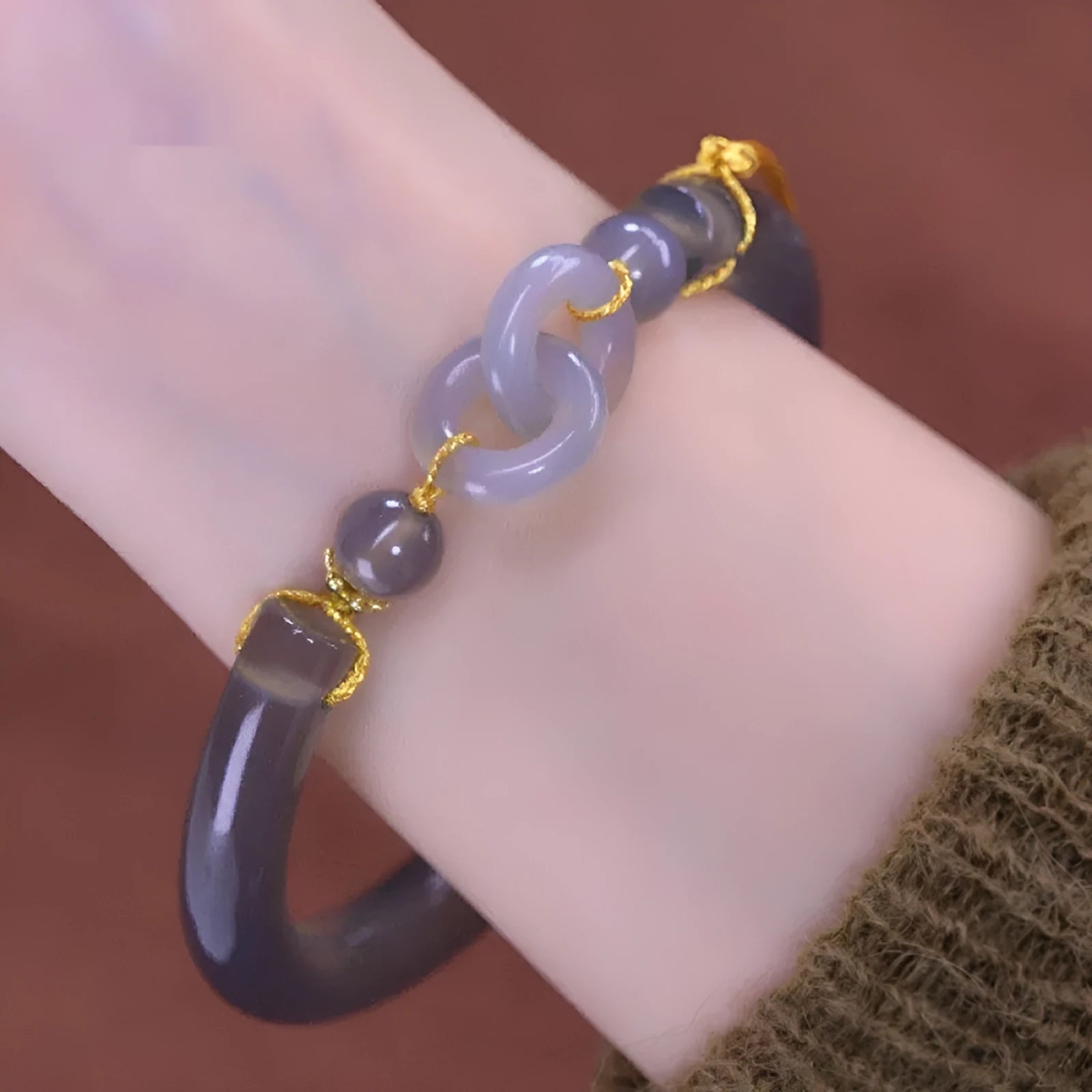 Close-up of a smoke purple grey agate half bracelet with a metal ring buckle closure on a wrist.