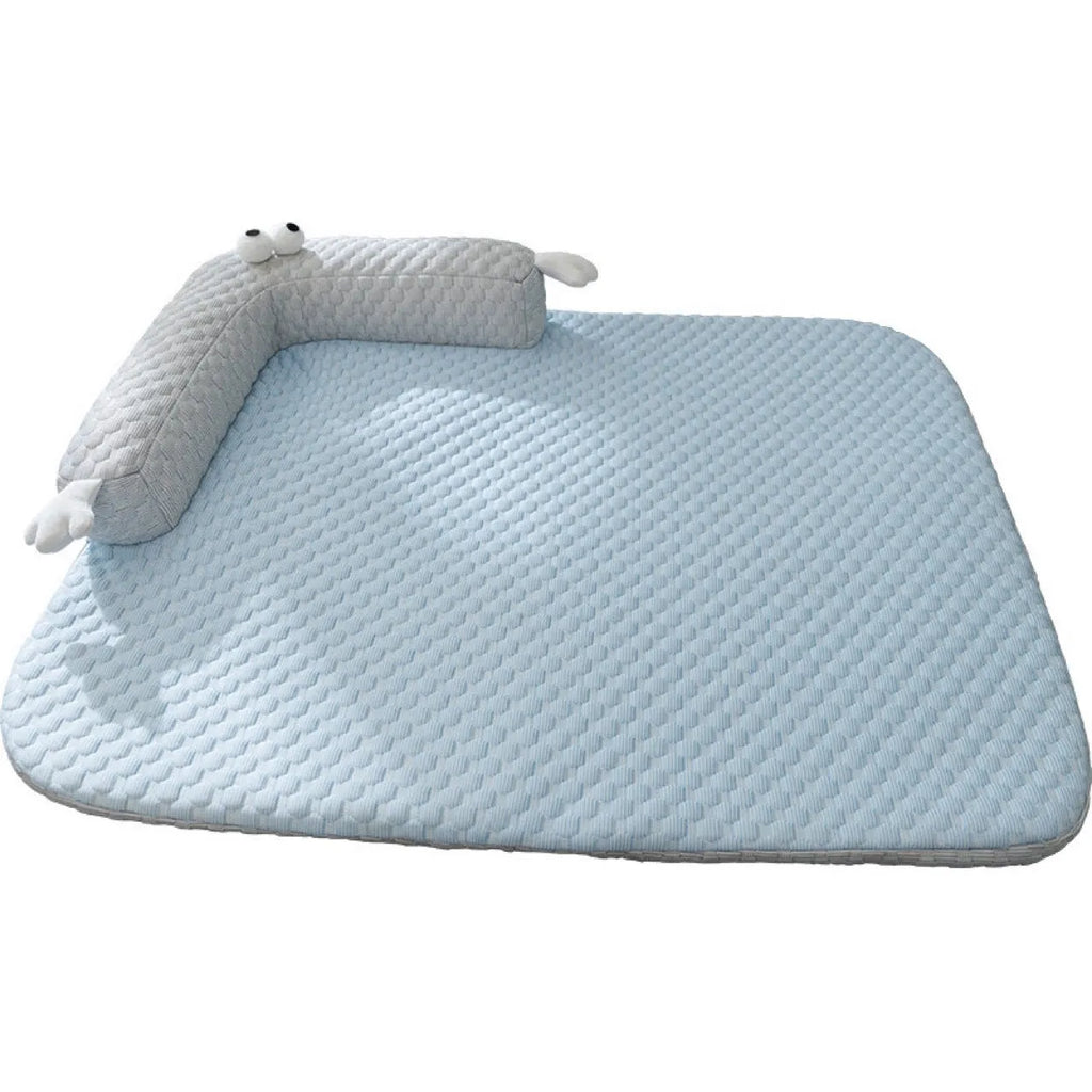 Blue pet bed cushion with big-eyed monster design on a wooden floor.