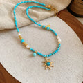Freshwater pearl necklace with a blue stone sun pendant on a delicate clavicle chain.