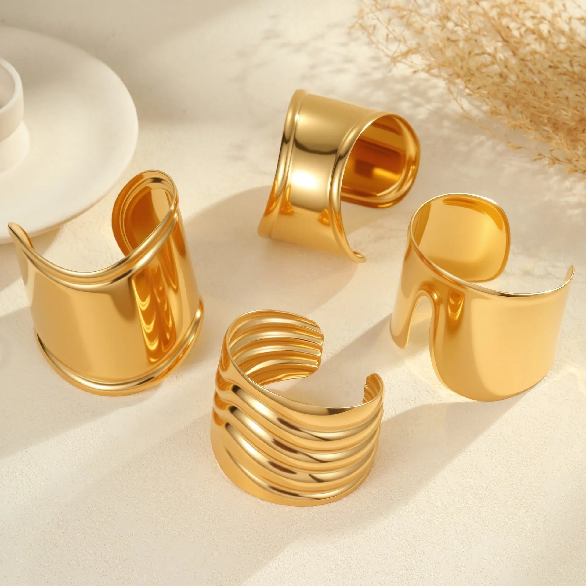 Gold plated wide women's bracelet with asymmetric geometric design and a niche opening.