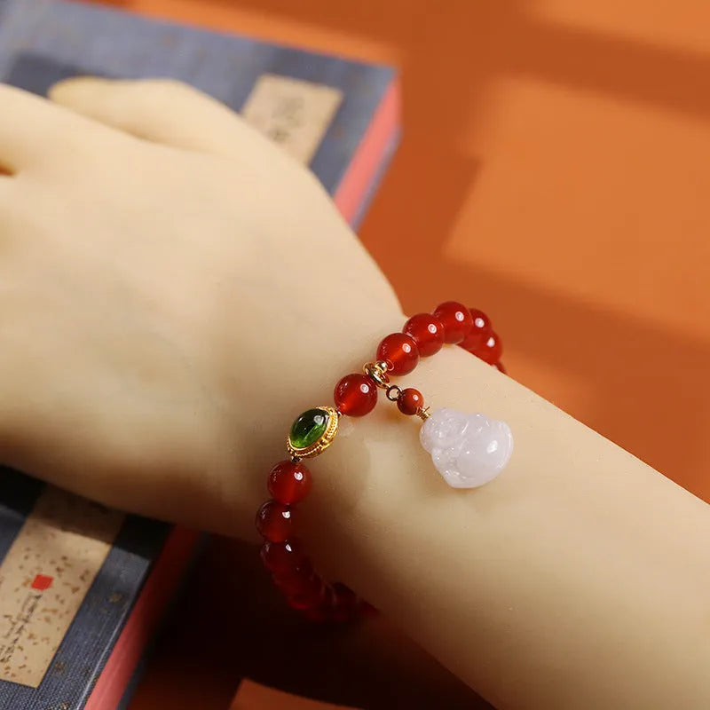 Chinese style geometric women's bracelet with red agate beads and a gold jade Maitreya Buddha pendant.