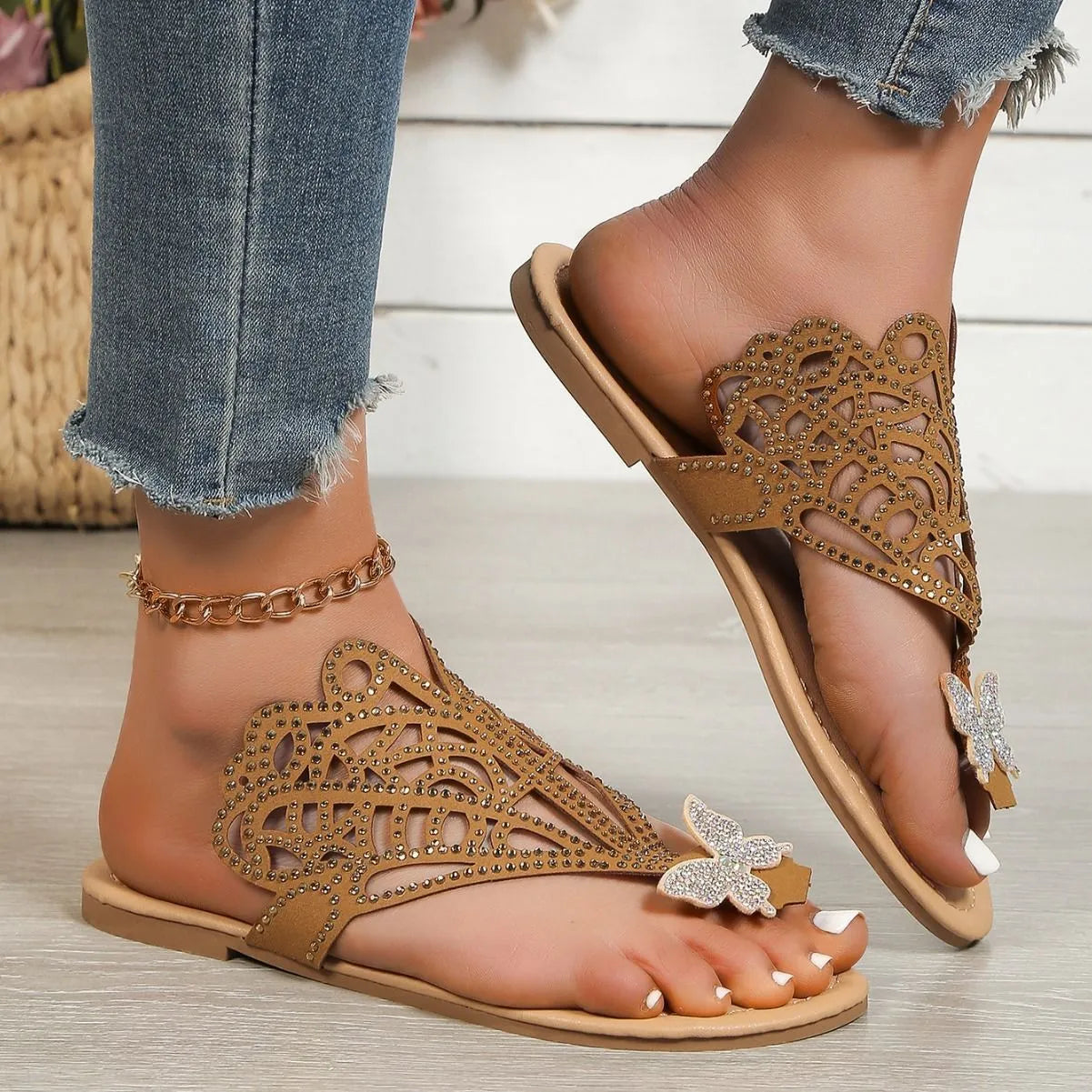 Women's black slip-on sandals with flip-toe design, rhinestone detail on the upper, and a flat rubber sole.