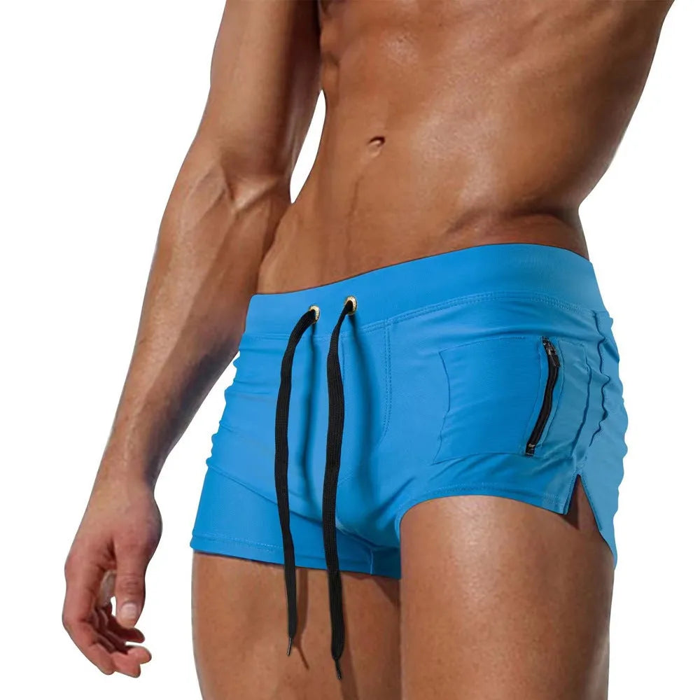 Men's black high-waist swimming trunks with lace-up front closure, shown on model during swimming activity