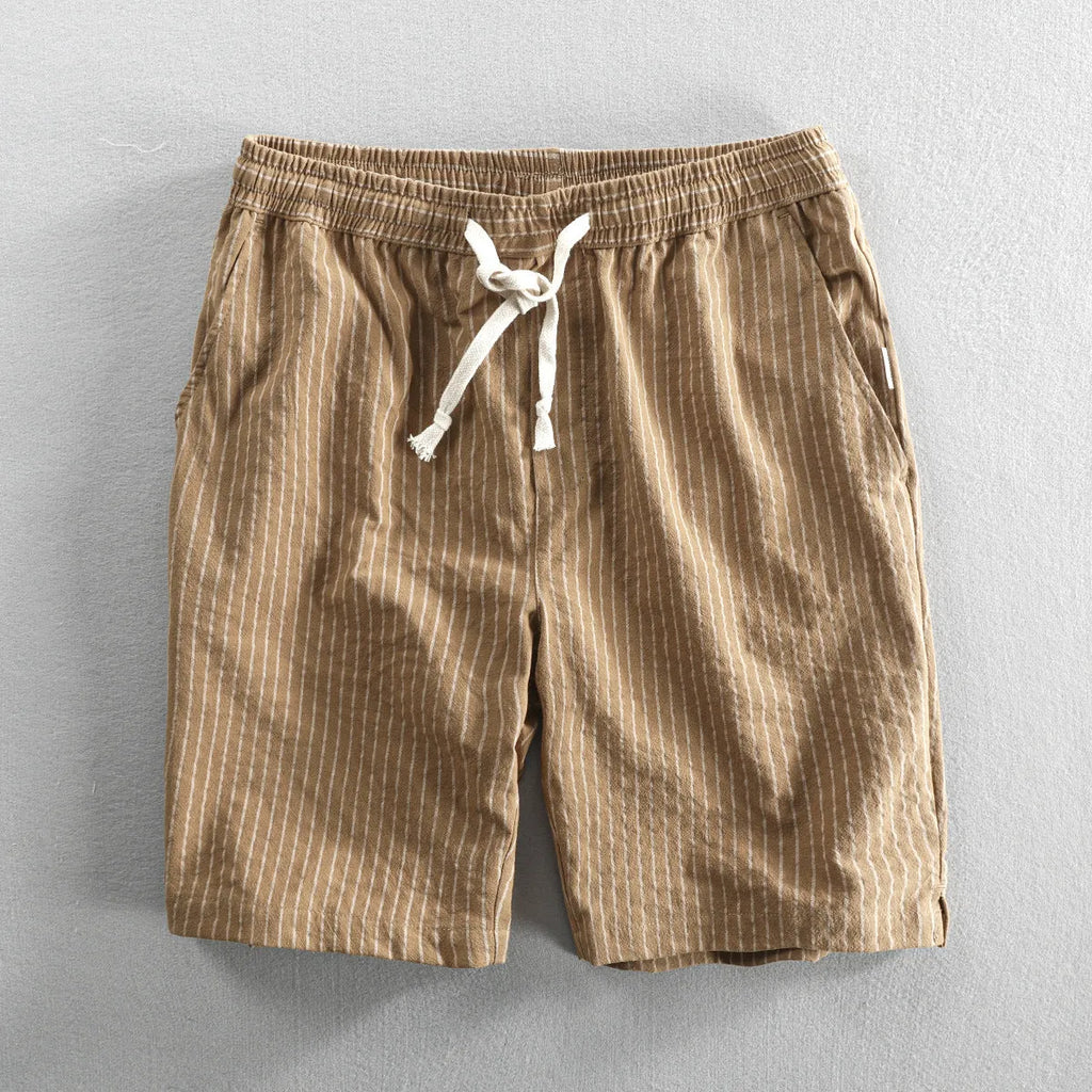 Men's striped cotton shorts in light blue with elastic waistband and micro elasticity, shown in a casual setting.